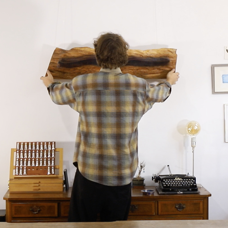 Lukas Böhm holding one of his sculptural artworks in his studio